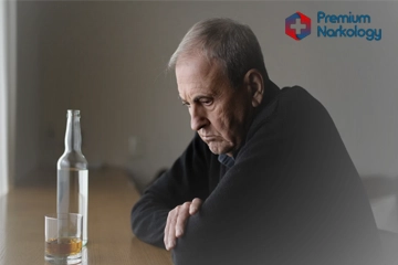 мужчина лежит на столе с стаканом в руке